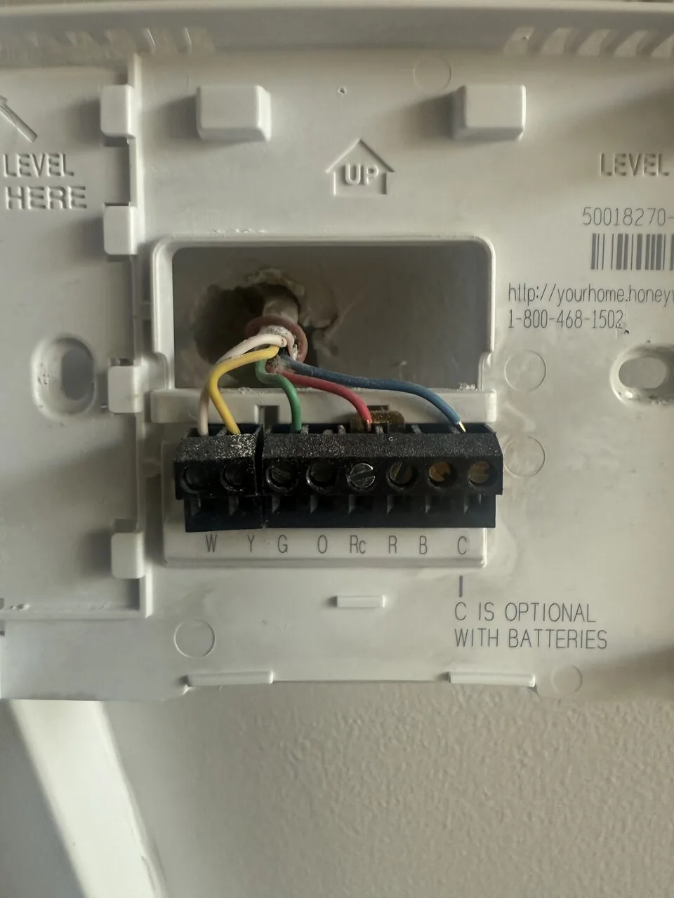 Smart thermostat base plate wired and installed on a wall