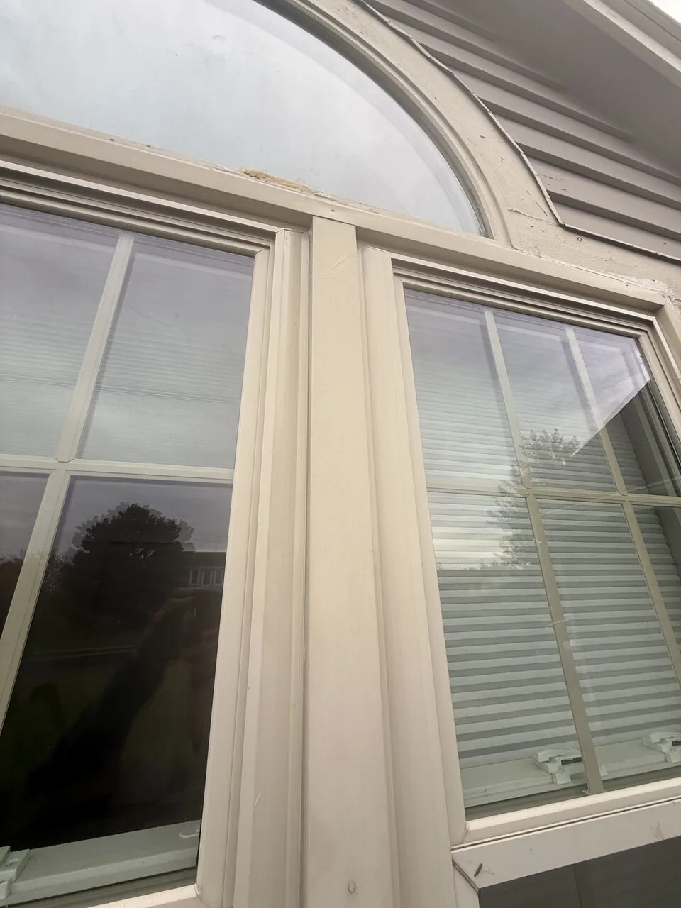 Interior windows with blinds neatly installed beneath an arched transom