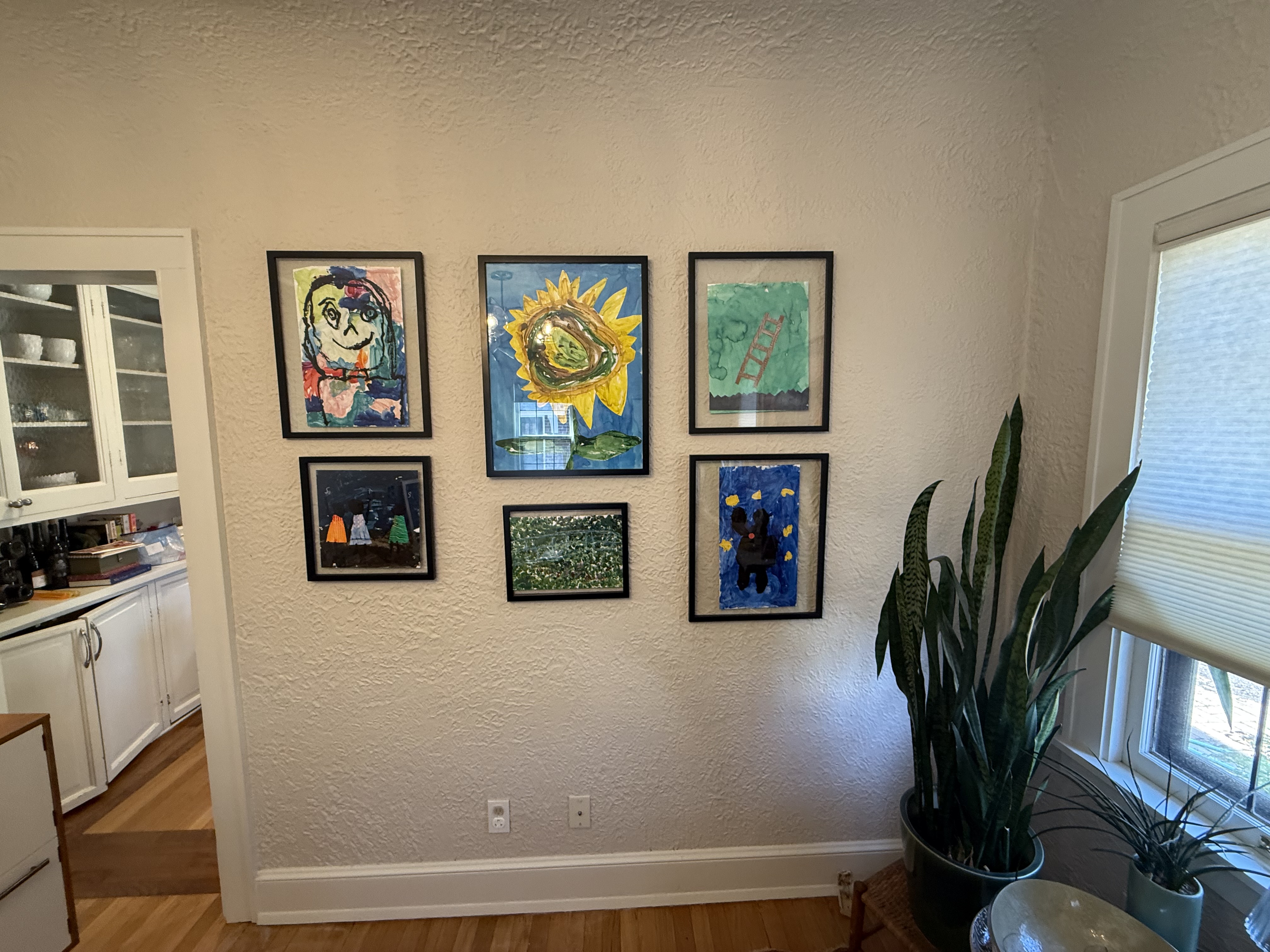 Kids artwork gallery wall with six frames installed by North Shore Fixers Milwaukee