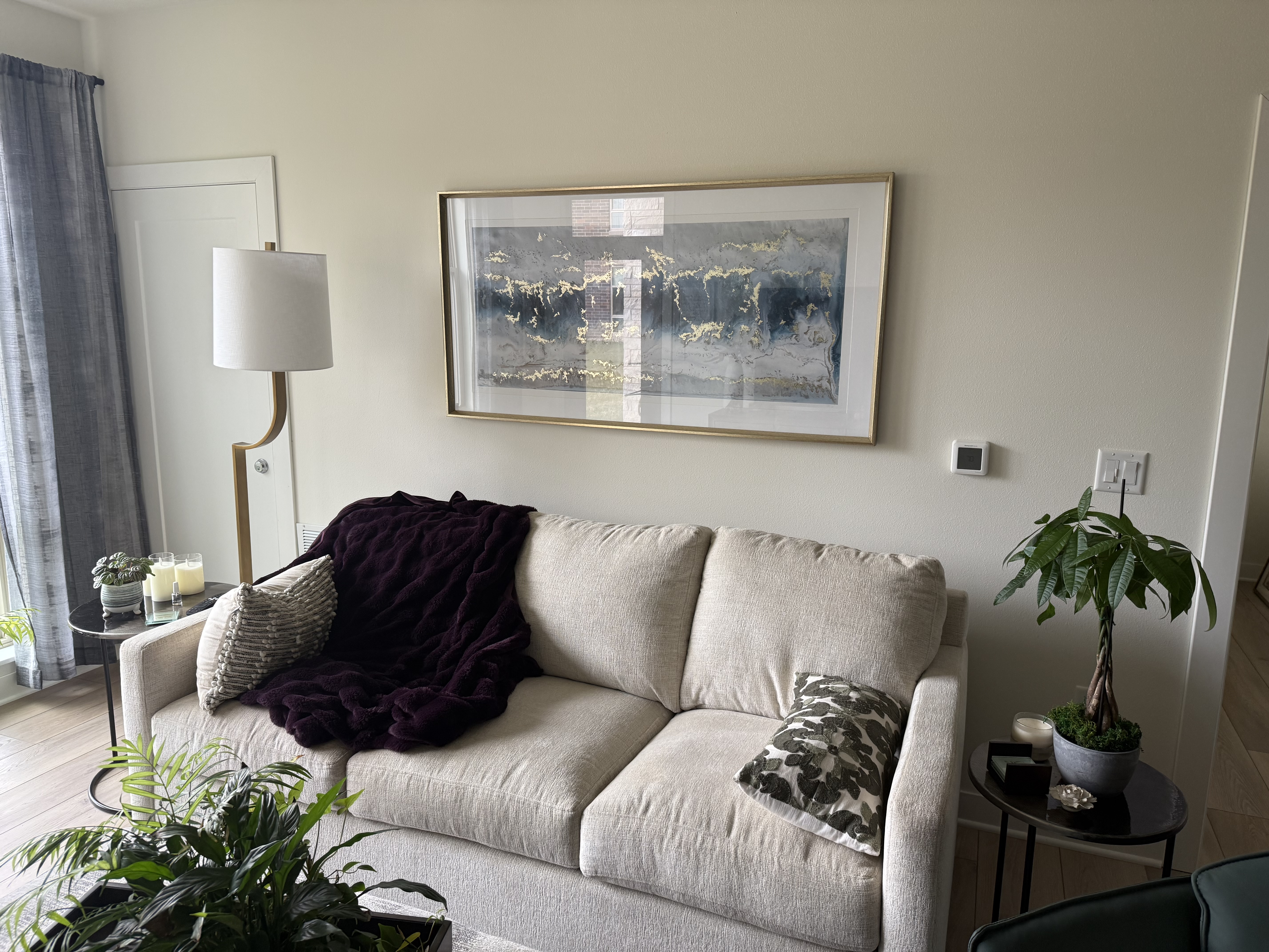 Large framed artwork hung above sofa in living room by North Shore Fixers Milwaukee